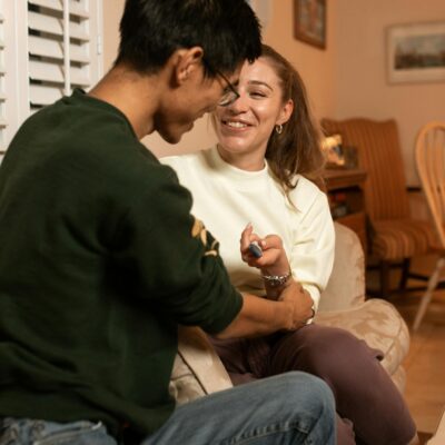 Man in Black Sweater Sitting Beside Woman in White Sweater