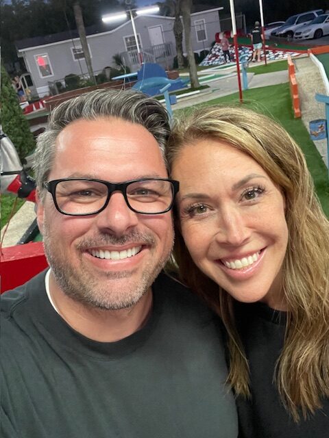 selfie of man and woman at mini golf course showing importance of date nights for couples