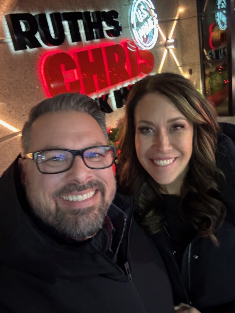 selfie of man and woman in front of Rith's Chris in Salt Lake City showing the importance of surprise date nights