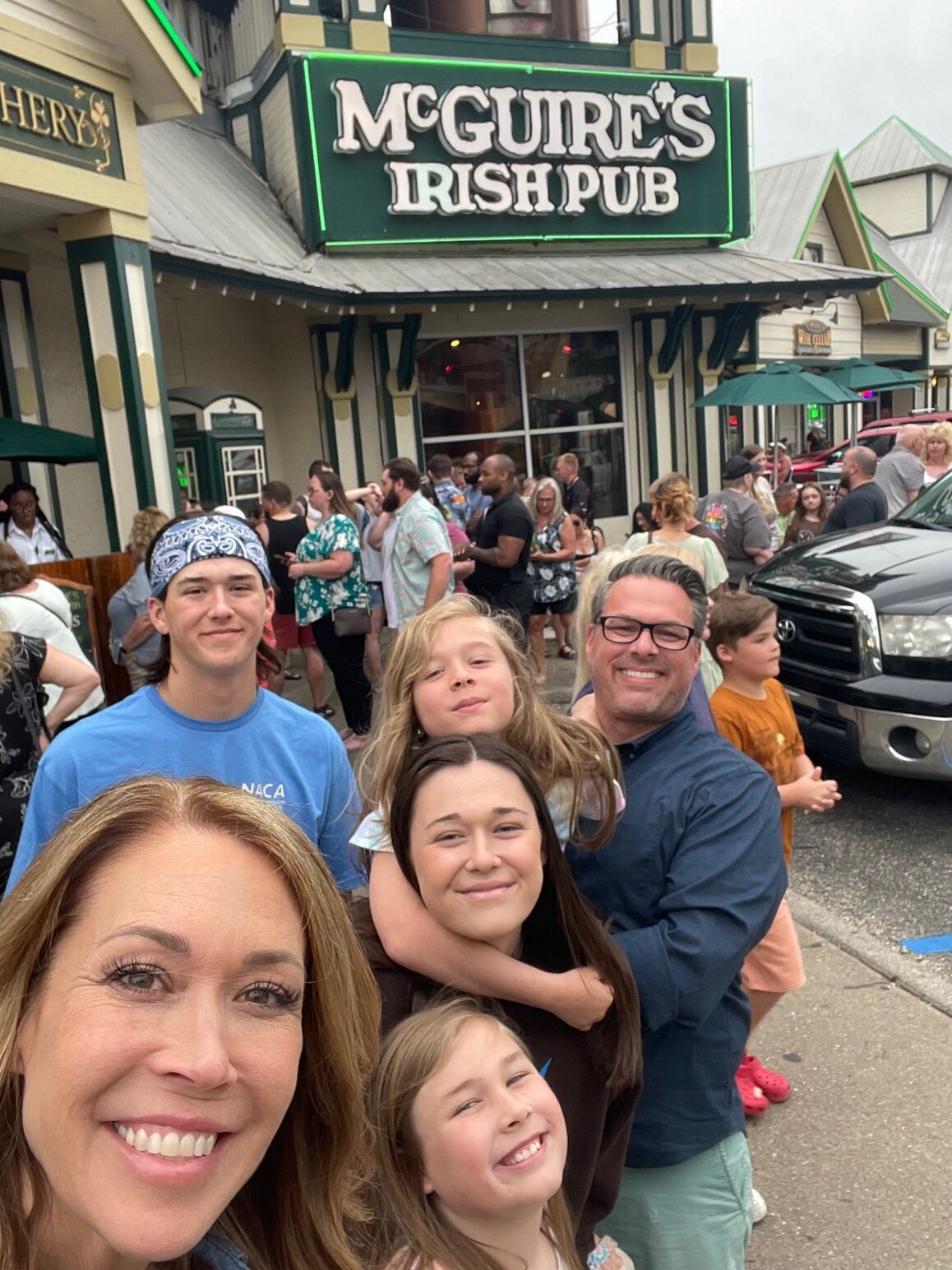 family of 6 taking a selfie in front of mcguire's irish pub in destin, florida