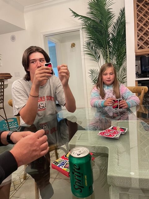 family sitting around a table playing uno card game