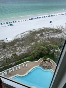 view from 17th floor balcony of jade east towers in destin, florida looking down at the pool and beach area