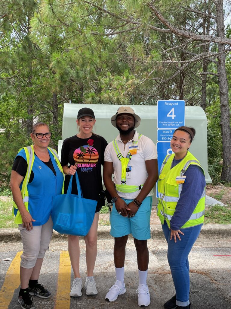 3 walmart employees pose with a lady celebrating their mothers day giveaway