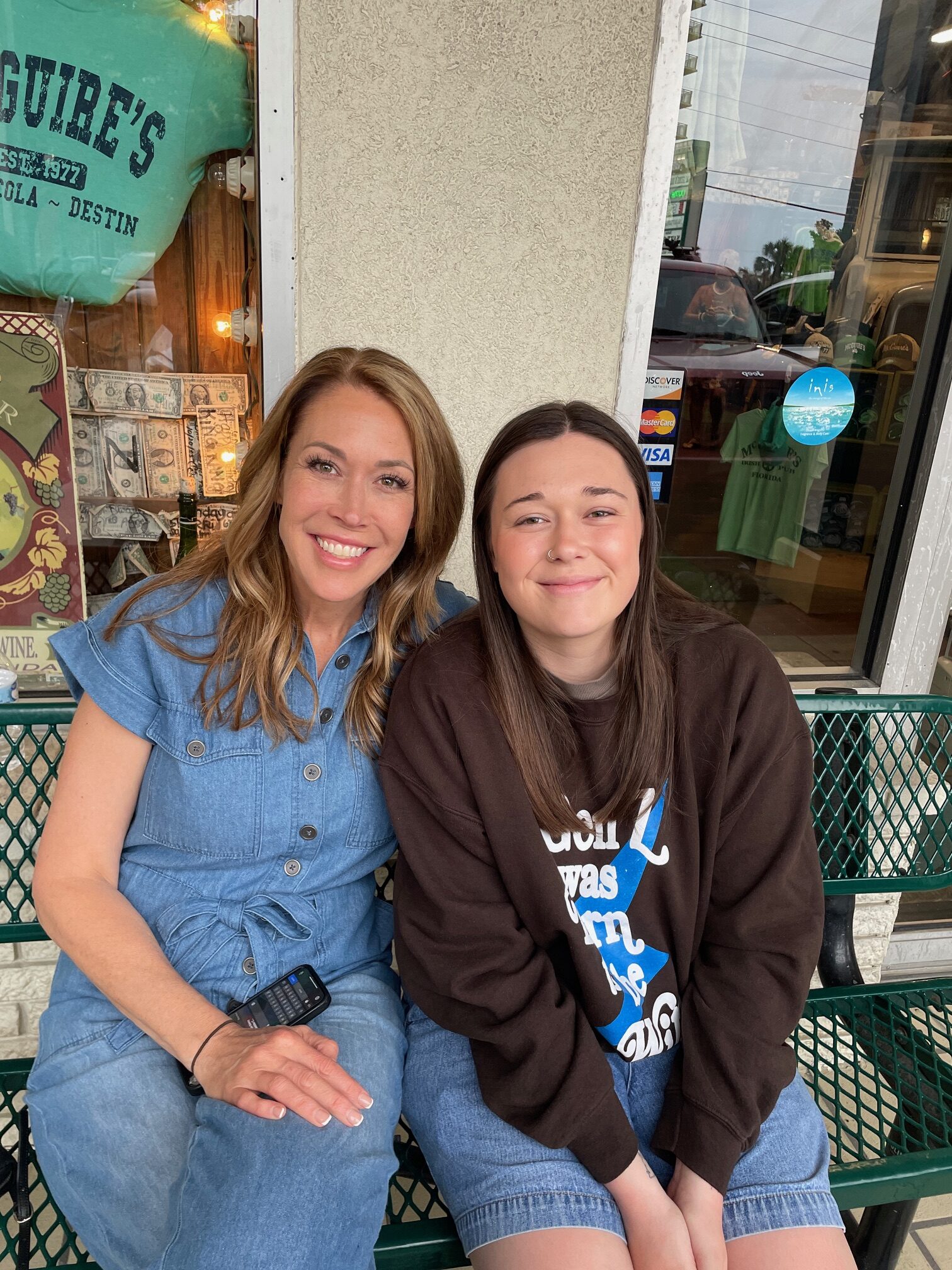 a mom and daughter sitting outside mcguire's irish pub in destin, florida