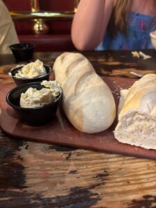 view of two loaves of sourdough bread and two cups of garlic butter from the spaghetti warehouse restaurant